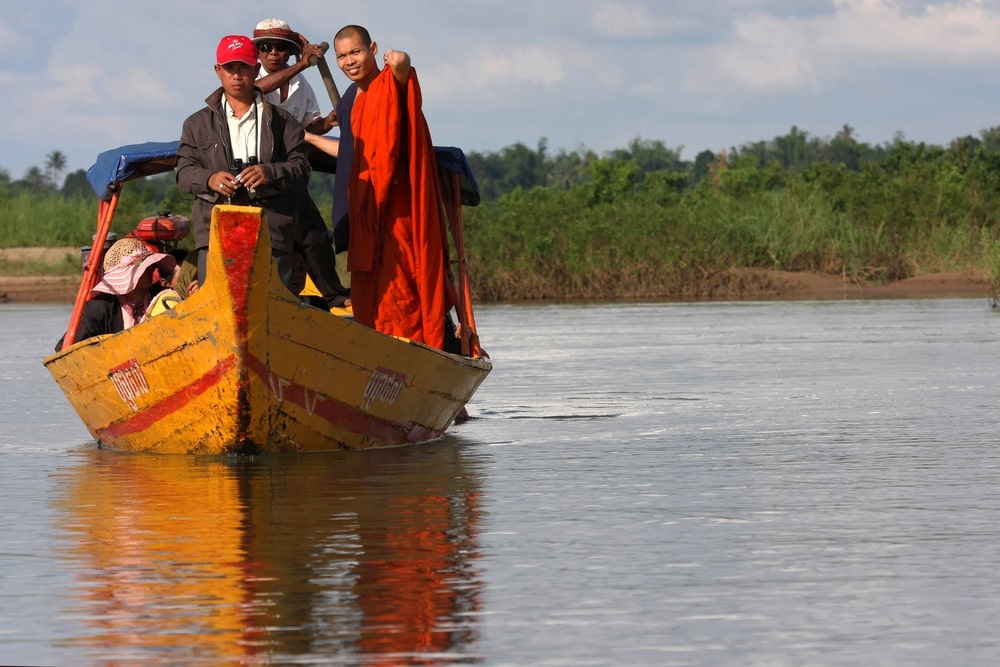 A monk looks for dolphins in Mekong River