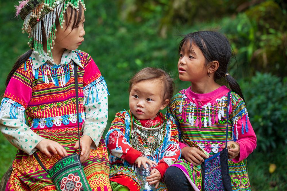 Cute Vietnamese girl in traditional dress embroiders with beads in Cat Cat Village